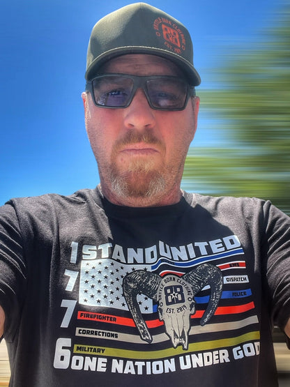 Handsome Manager wearing a black custom printed graphic tee “Stand United” Tee by Battle Born Clothing – Honor & Strength Woven In - Shop Battle Born Clothing Thin blue line thin red line American flag
